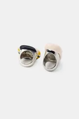Pack de dos anillos: uno rectangular con diseño marmolado en tonos beige y marrón, y otro ovalado con rayas horizontales en amarillo, blanco, negro y marrón. Ambos anillos tienen una base metálica y una aplicación de resina.