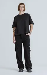 Pantalon cargo de corderoy negro con corte regular, cintura elástica y seis bolsillos, incluyendo dos bolsillos laterales con solapa.