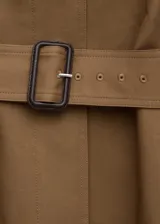 Chaqueta larga de algodón color marrón tostado, estilo gabardina, con cuello camisero, cierre frontal oculto con botones, mangas largas con presillas en los puños y cinturón ajustable con hebilla oscura.