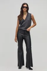 Pantalón de cuero negro, de corte ajustado en la parte superior y acampanado en la parte inferior.