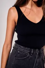 Top de tejido de punto acanalado, color negro, con escote en V y diseño ajustado al cuerpo.