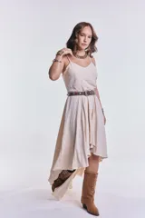 Vestido midi color beige de breteles finos, corte asimétrico y falda con volados.