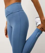 Legging deportiva de microfibra color azul, con cintura alta de diseño cruzado en forma de V y ajuste ceñido al cuerpo.