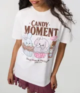 Remera de algodón color blanco de corte regular, con cuello redondo y mangas cortas. Presenta un estampado frontal multicolor con animales sobre cupcakes y el texto "Candy Moment".