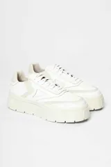 Zapatilla de gamuza color tostado con plataforma alta de goma blanca y cordones al tono.