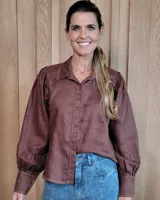 Camisa de lino color marrón, con mangas largas abullonadas, puños ajustados y costuras a la vista en color contrastante.