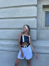 Top corto negro de ecocuero con tirantes finos plateados y espalda descubierta.