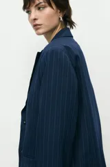 Blazer sastrero negro de corte oversize con solapas de muesca y cierre frontal con dos botones.