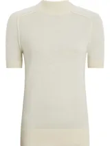 Sweater de lana merino color crema, de corte slim, cuello perkins y manga corta. Presenta detalles de puntadas en los hombros y ribetes de canalé en cuello, puños y bajo.