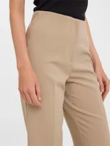 Pantalón sastrero de tiro alto y corte recto, color beige, con pinzas frontales y tejido elástico.