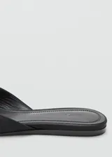 Zapato destalonado plano de color negro con punta redonda, confeccionado con corte de poliéster y suela de caucho.