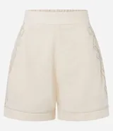 Short de cintura alta color crema, con bolsillos laterales y bordados abstractos en los costados.