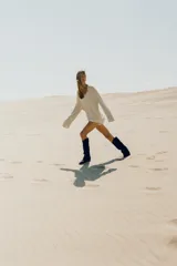 Bota alta de estilo cowboy confeccionada en serraje de color azul marino, con tacón medio en bloque y puntera perfilada. Presenta costuras decorativas en el cuerpo y diseño de calce fácil.