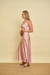 Vestido largo de satén al bies color rosado, con escote buche en el pecho y apliques dorados en los breteles.