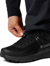 Pantalón de senderismo Columbia Titanium color negro, de tiro alto y corte ajustado. Confeccionado en tejido técnico repelente al agua y manchas, cuenta con bolsillos laterales con cierre, cintura parcialmente elástica y refuerzos en las rodillas para mayor movilidad.