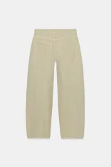 Jeans de tiro medio y corte barrel con diseño de perneras curvadas, tiro medio, trabillas para cinturón y cinco bolsillos. Presenta lavado clásico y costuras pespunteadas decorativas en la parte delantera.