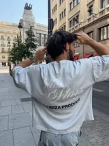 Remera celeste de corte holgado con estampado en la espalda que dice "Ittai Stars" en letras cursivas y "An Ibiza Produce" en mayúsculas.