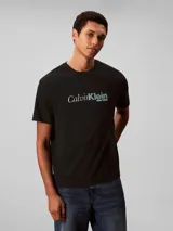 Remera de algodón con cuello redondo y manga corta, presenta un estampado frontal con el logo de la marca en estilo cursivo.