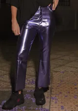 Pantalón de ecocuero color violeta metalizado, con corte capri semi oxford y tiro medio-alto. Presenta cierre frontal con botón metálico y bolsillos traseros.