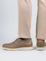 Zapato de vestir estilo derby marca Hush Puppies, confeccionado en cuero color marrón con suela de EVA en tono beige. Presenta cordones al tono y detalle de logo grabado en el lateral.