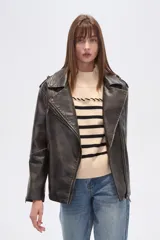 Chaqueta estilo biker de eco-cuero con efecto desgastado, color negro. Presenta cuello solapa, cierre asimétrico frontal, bolsillos con cierre y hombreras.