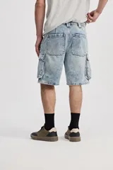 Bermuda cargo de jean color azul con lavado de efecto desgastado, corte amplio y bolsillos laterales con solapa.