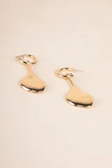 Aros dorados tipo argolla con dije colgante irregular.