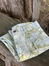 Bombacha de campo confeccionada en gabardina 100% algodón de color celeste con estampado botánico en tonos verde militar, con cierre de botones y trabillas para cinturón.