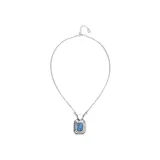 Collar de cadena fina con dije rectangular de metal plateado y cristal facetado en color azul en el centro.