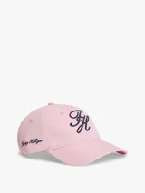 Gorra de béisbol de seis paneles Tommy Hilfiger, color rosado, confeccionada en puro algodón. Presenta un diseño con ojales de ventilación, botón superior y visera curvada con costuras texturizadas. Destaca por el logo de la marca bordado en fuente script azul marino en la parte frontal y lateral.