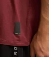 Remera deportiva de hombre con tecnología dry fit, cuello redondo y manga corta. Presenta un diseño liso en color beige con una pequeña etiqueta decorativa en el dobladillo.