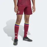 Short de fútbol Adidas, versión Fan, color granate (similar al rojo oscuro), con detalles en amarillo en los bordes. Presenta el escudo de la Federación Venezolana de Fútbol (FVF) bordado en el muslo izquierdo.