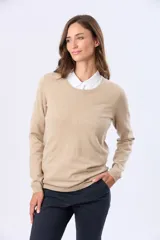 Buzo tejido de hilo de algodón color beige, de manga larga y cuello redondo clásico.