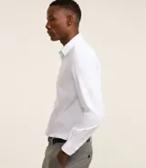 Camisa de corte regular confeccionada en microfibra, con cuello inglés, manga larga y cierre frontal abotonado. Presenta un diseño liso y minimalista, ideal para un estilo formal o de oficina.