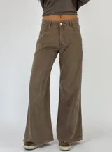 Pantalón de jean beige de corte acampanado con terminación desflecada.