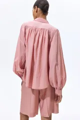 Bermuda de corte holgado en tejido de mezcla de viscosa, color rosado. Modelo con cierre, pretina prolongada y bolsillos al bies, con pinzas y raya planchada en las piernas.