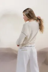 Sweater color crema con rayas horizontales y mangas largas.