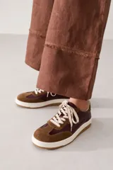 Zapatillas de cuero con diseño de paneles en tonos marrón y bordó, con suela de goma blanca y cordones jaspeados.