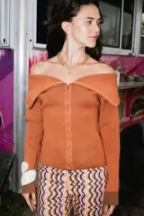 Saco tejido de punto color naranja con efecto bicolor, escote off-shoulder y cierre frontal bidireccional.