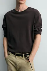 Camiseta relaxed fit de manga larga y cuello redondo, confeccionada en tejido de mezcla de algodón y lino, en color negro.