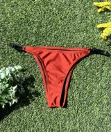 Bikini color ladrillo con corpiño triangular con breteles de elástico y bombacha colaless regulable. El corpiño tiene abertura para agregar tazas. Hecho con lycra premium metalizada.