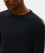 Conjunto de pijama masculino compuesto por una remera de manga larga con cuello redondo y un pantalón largo a juego. Ambas piezas presentan un diseño liso y minimalista, confeccionadas en tejido de modal suave y transpirable.