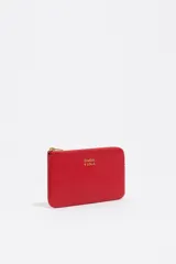 Monedero pequeño de piel vacuna color rojo, con textura granulada, cierre de cremallera dorado y logo metálico de Bimba y Lola en dorado.