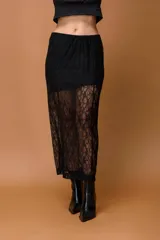 Falda larga de encaje negro con diseño de transparencias y forro corto integrado. Presenta una silueta recta y fluida con acabado delicado.