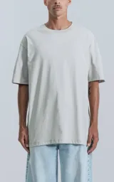 Remera de corte relajado con hombros caídos y silueta amplia, confeccionada en algodón premium. Presenta cuello redondo y mangas cortas, con un diseño minimalista y versátil.