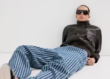 Pantalón estilo tejano vaquero de algodón con diseño largo y recto, tiro medio y estampado de rayas. Cuenta con dos bolsillos laterales y cierre de lazo en la cintura.