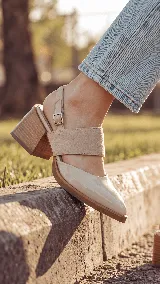 Zapato de cuero color nude, con punta fina, taco ancho de 6 cm, tira ajustable en el talón con hebilla metálica y capellada combinada con detalles en gamuza.
