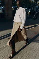Camisa de popelín color blanco, con cuello solapa, manga larga y bajo abullonado con elástico interior. Cierre frontal con botones.