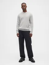 Buzo de punto con textura acanalada vertical, cuello redondo y mangas largas con puños elásticos.