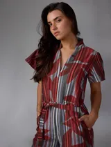 Mono de lino mezcla con estampado vegetal en tonos rojos, grises y blancos, de manga corta, escote en V y piernas amplias con cinto incorporado para ajustar la cintura.